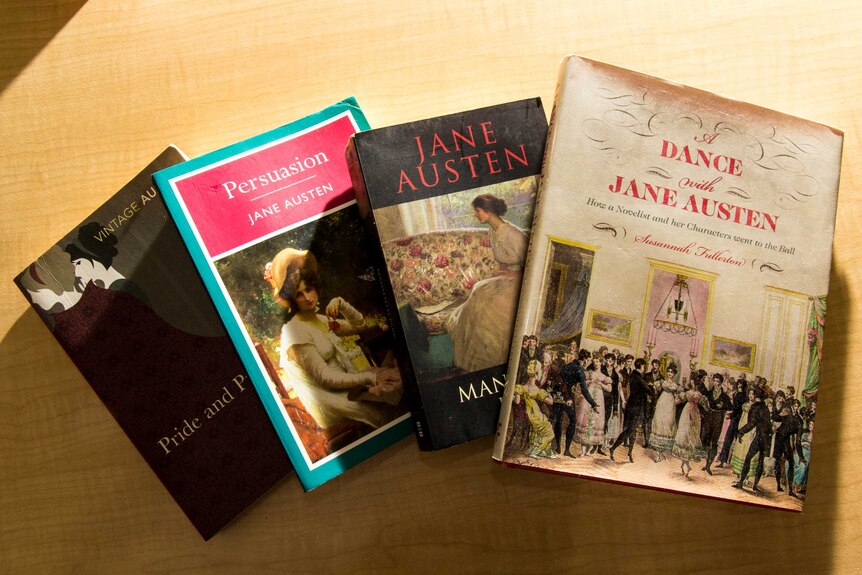 A collection of Jane Austen books sit on a table.