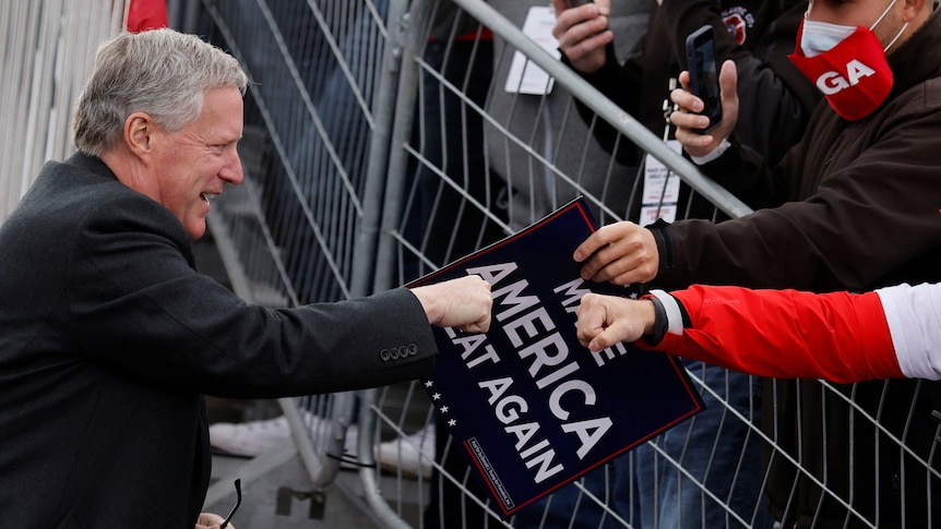 White House Chief of Staff Mark Meadows greets supporters of Donald Trump.