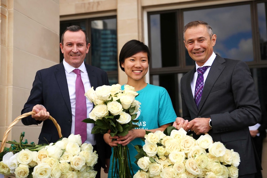 Belinda Teh, the Premier and Health Minister holding baskets white roses on the steps of WA parliament.