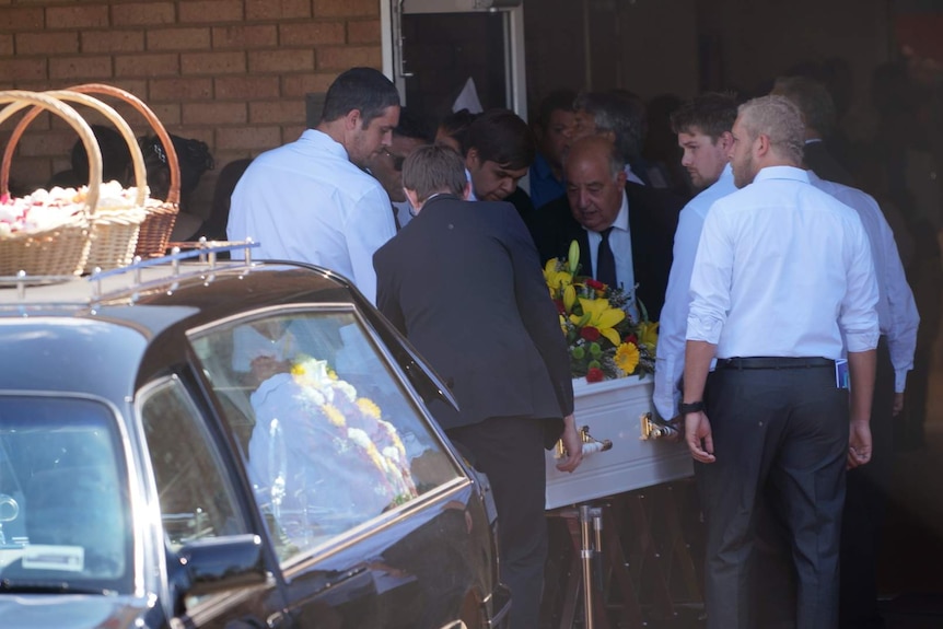 Young men help carry Elijah Doughty's coffin inside.