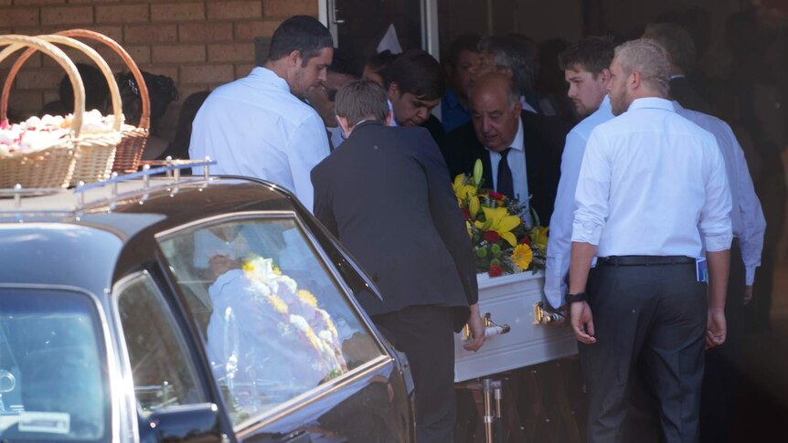 Young men help carry Elijah Doughty's coffin inside.