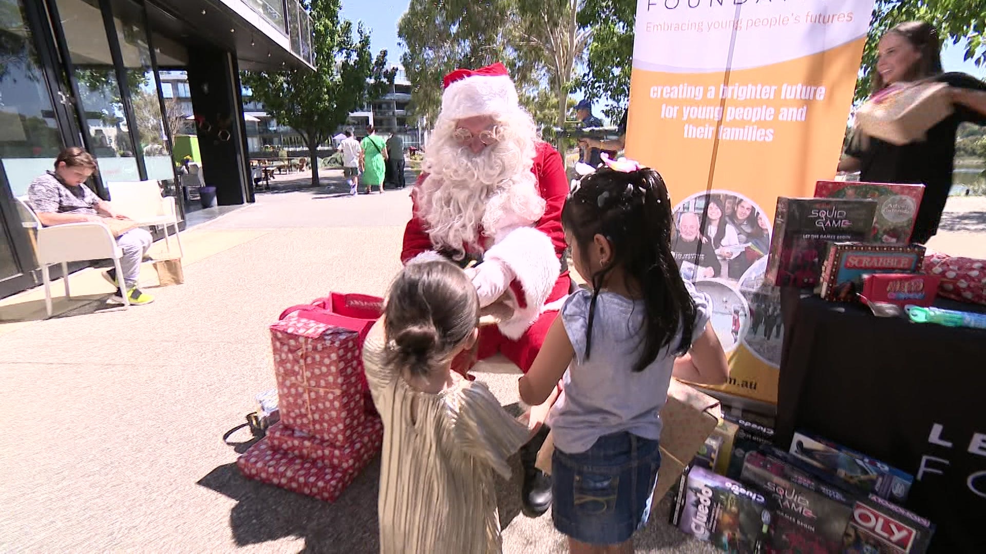 Santa sits as two young girls approach. 