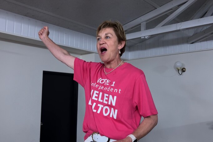 woman in pink shirt celebrates with fist in the air