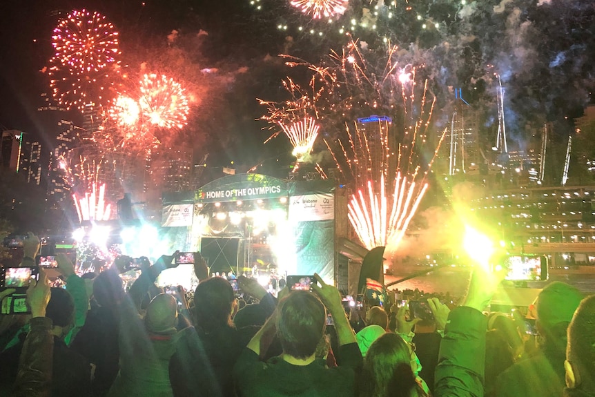 Fireworks over Brisbane as crowds cheer.