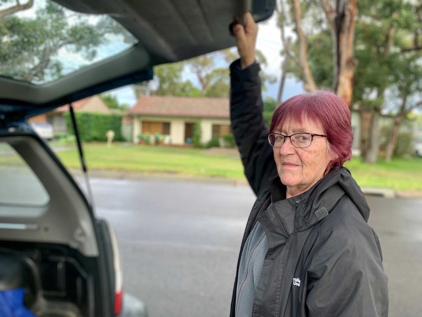 Margaret Hunt holds the tailgate of her wagon.