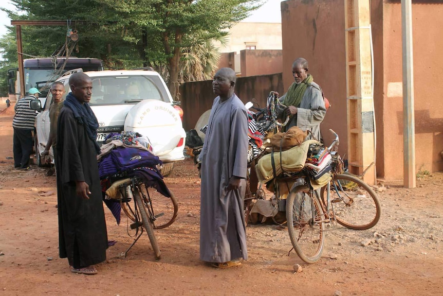 Men sell fabric on a road in Mali