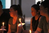 Mourners hold candles at the vigil for the allegedly murdered woman.