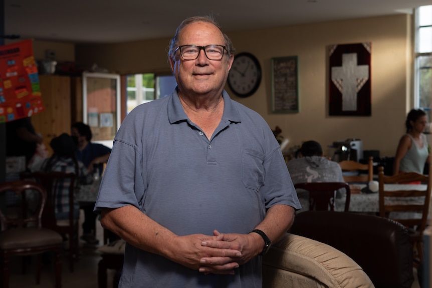 Father Michael stands smiling with folded hands.