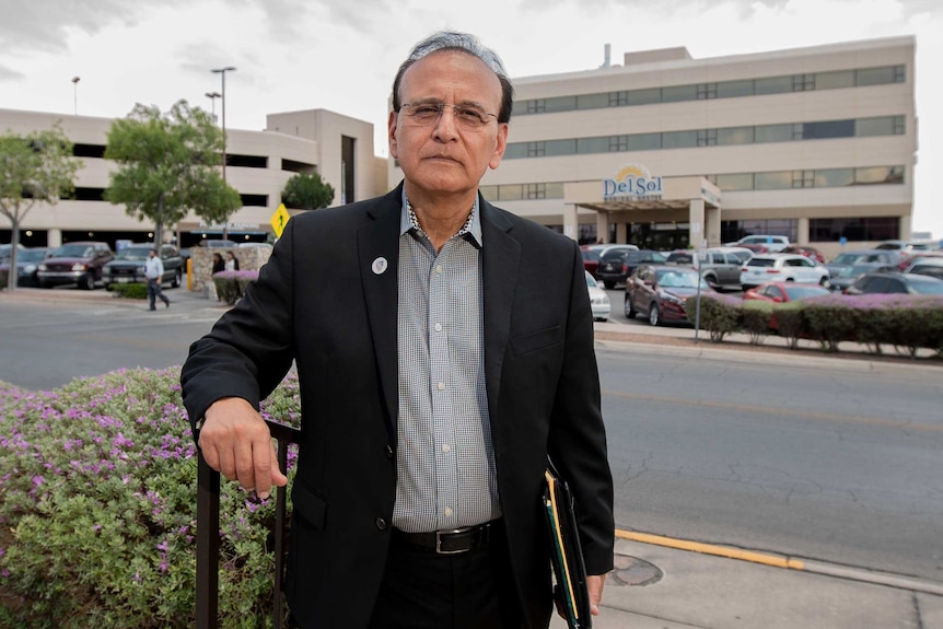 A man stands outside a hospital