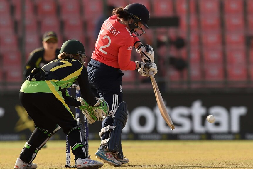 England's Tammy Beaumont (R) plays as Australian wicketkeeper Alyssa Healy looks on at World T20.