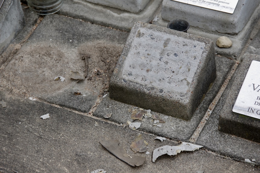 A nameless gravestone, with cement debris.