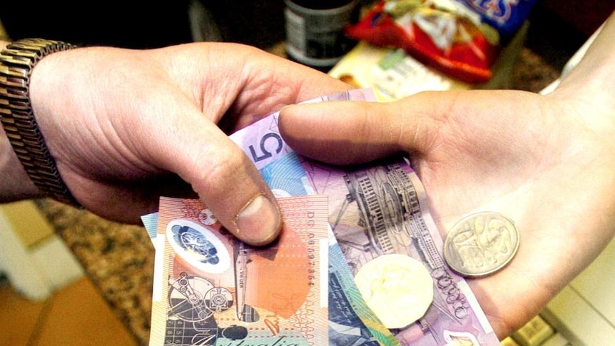 A shop assistant hands over change to a customer