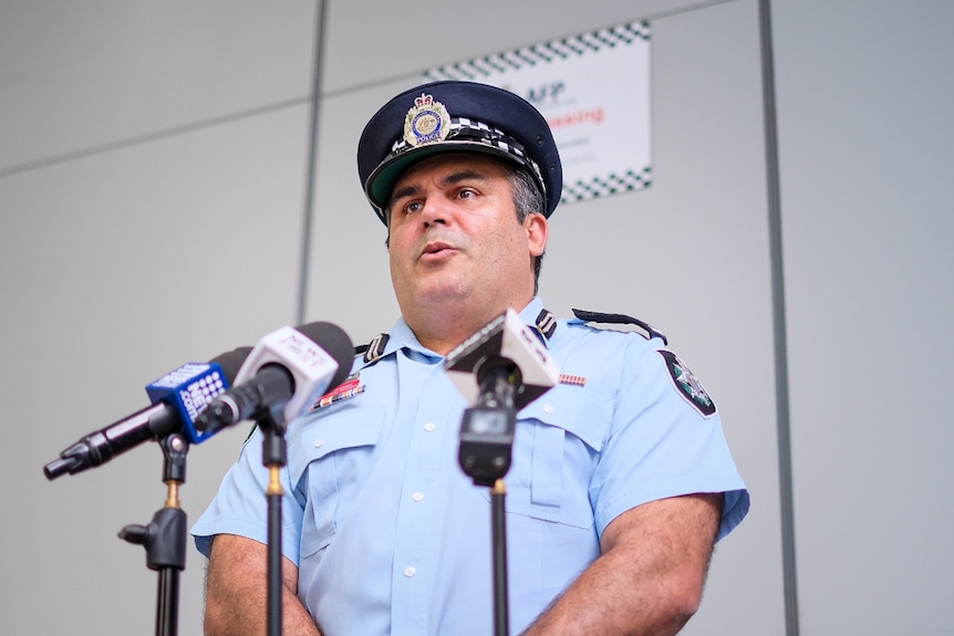 A police officer speaks into a microphone