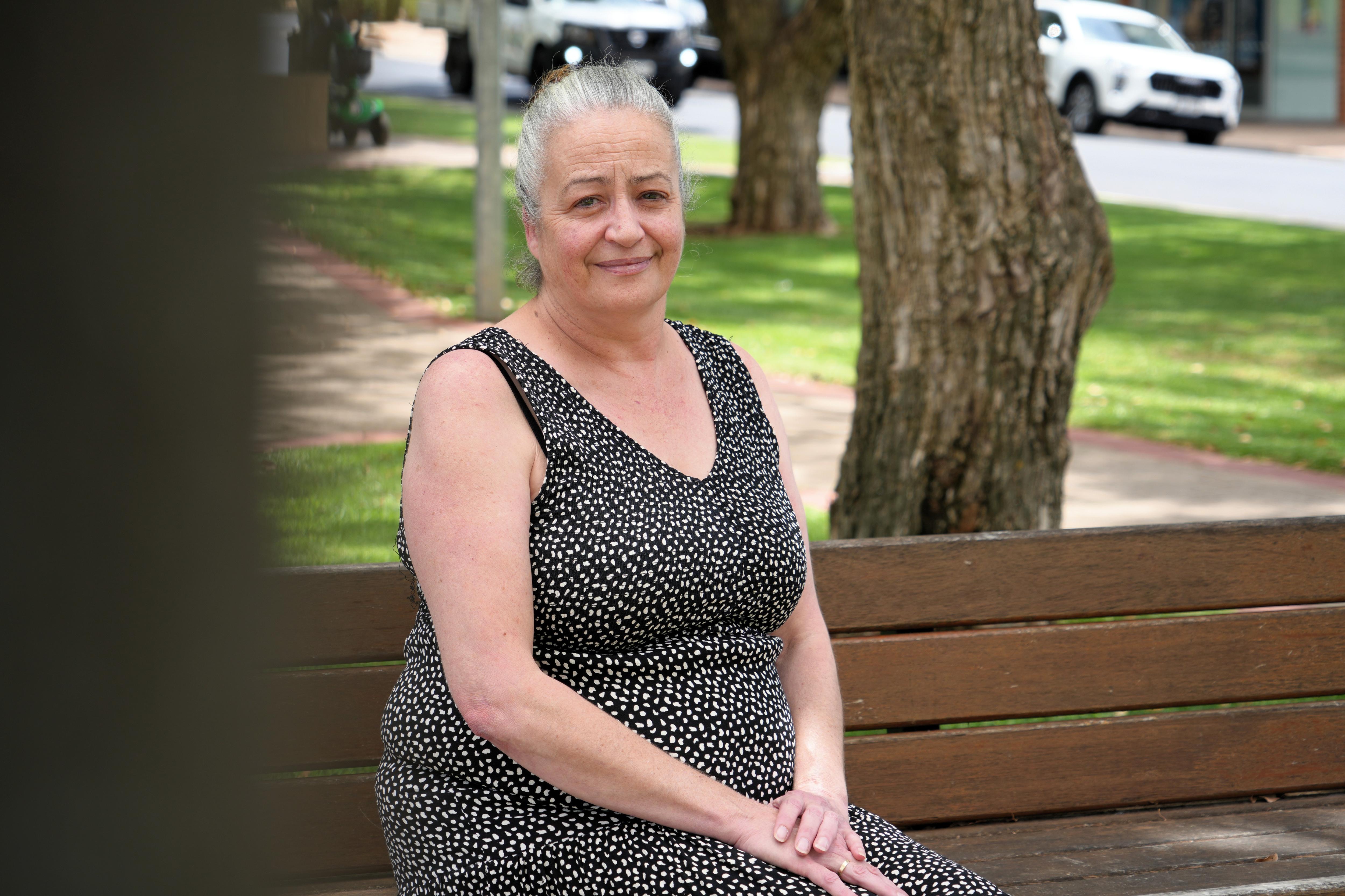 Una mujer mira a la cámara con una mirada sombría. 