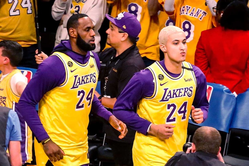 LeBron James and Kyle Kuzma run onto the court wearing Kobe Bryant's number 24 jersey.