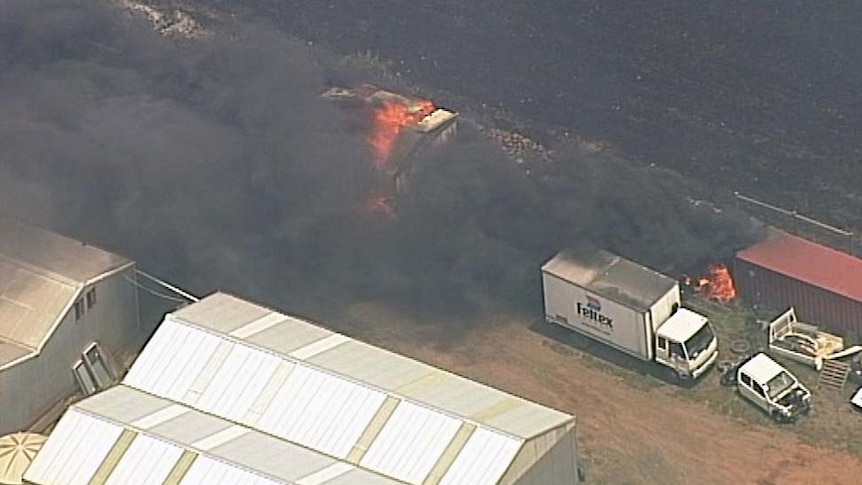 Black smoke coming from some buildings on fire near Little River.