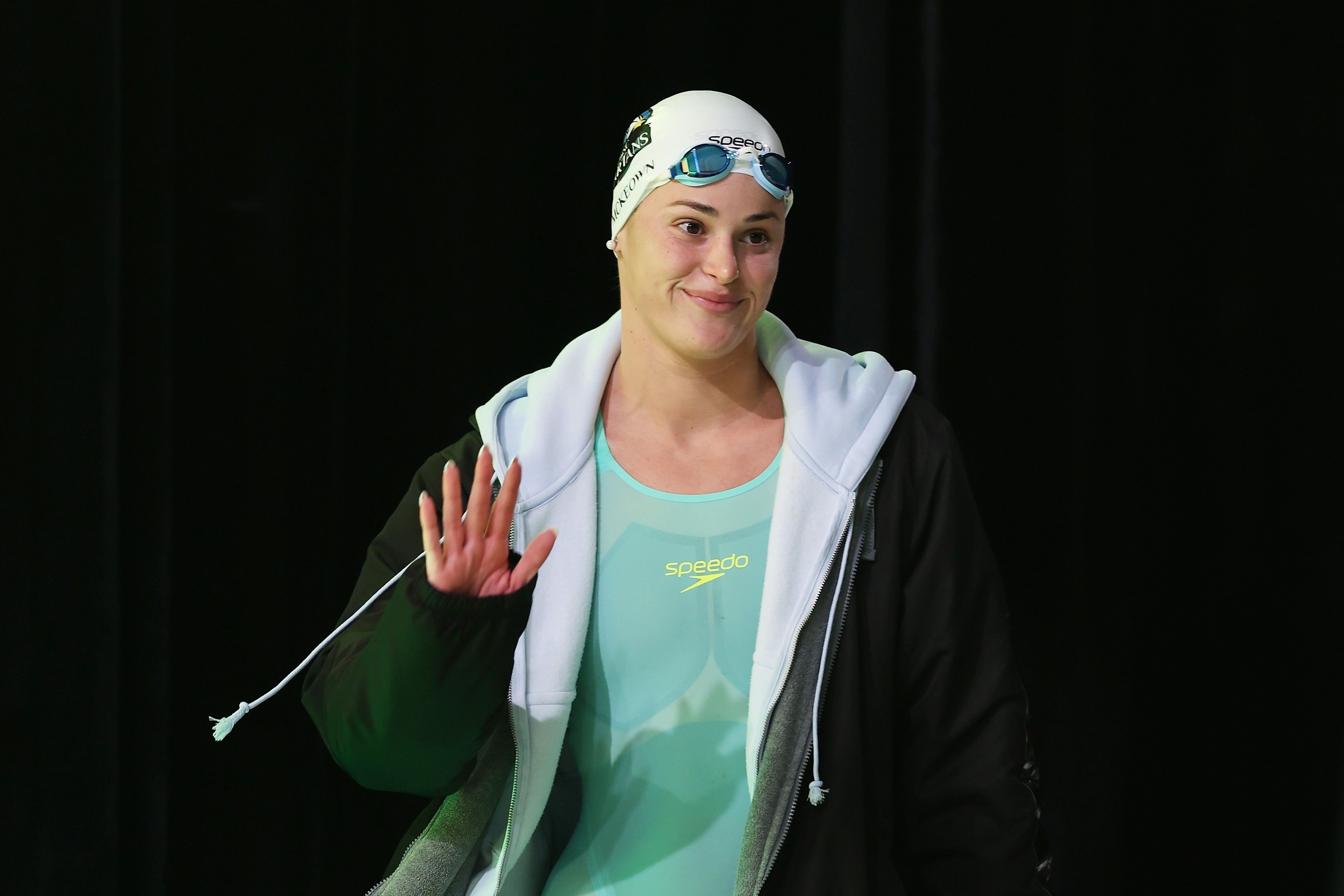 Swimmer Kaylee McKeown waves as she walks to the blocks.