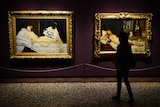 Silhouette of a woman stands in front of Edouard Manet's painting Olympia