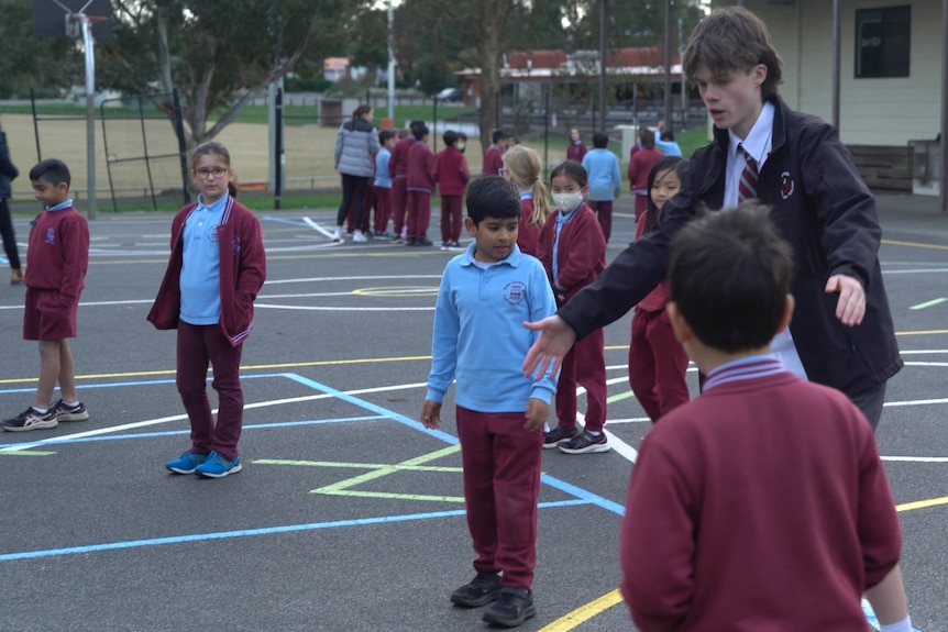 Noah shows primary school students how to play downball.