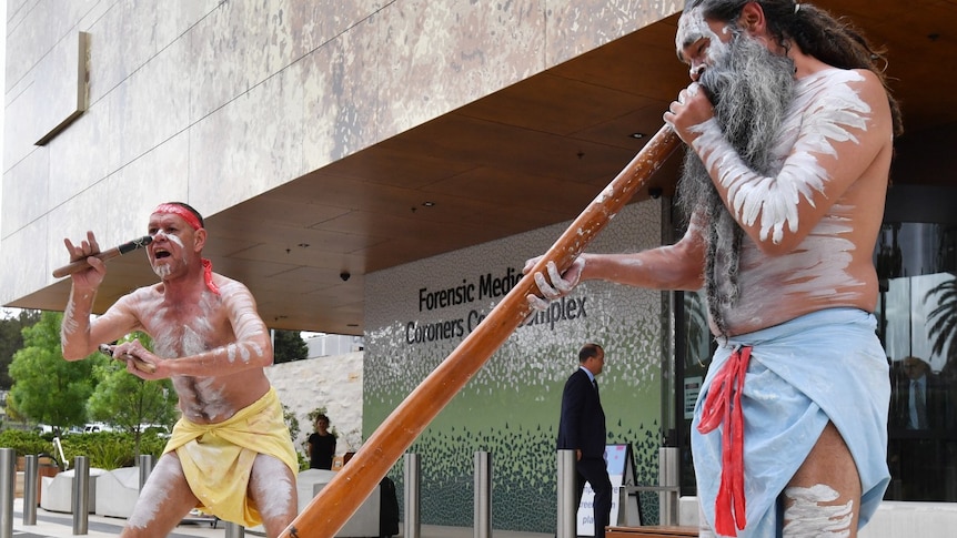 Aboriginal dancers perform outside the Lidcombe Coroners Court.