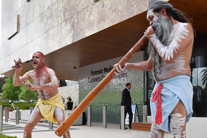 Aboriginal dancers perform outside the Lidcombe Coroners Court.
