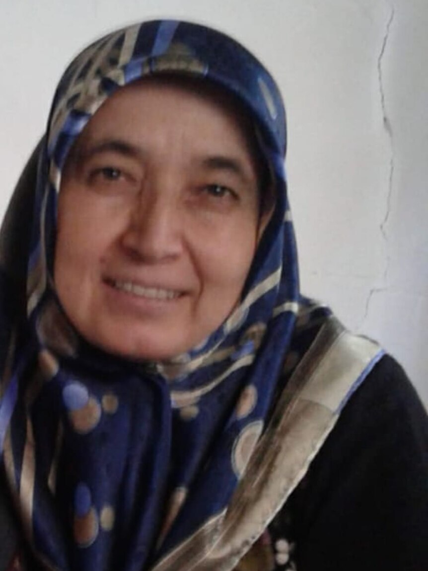 A woman smiling in a blue patterned headscarf