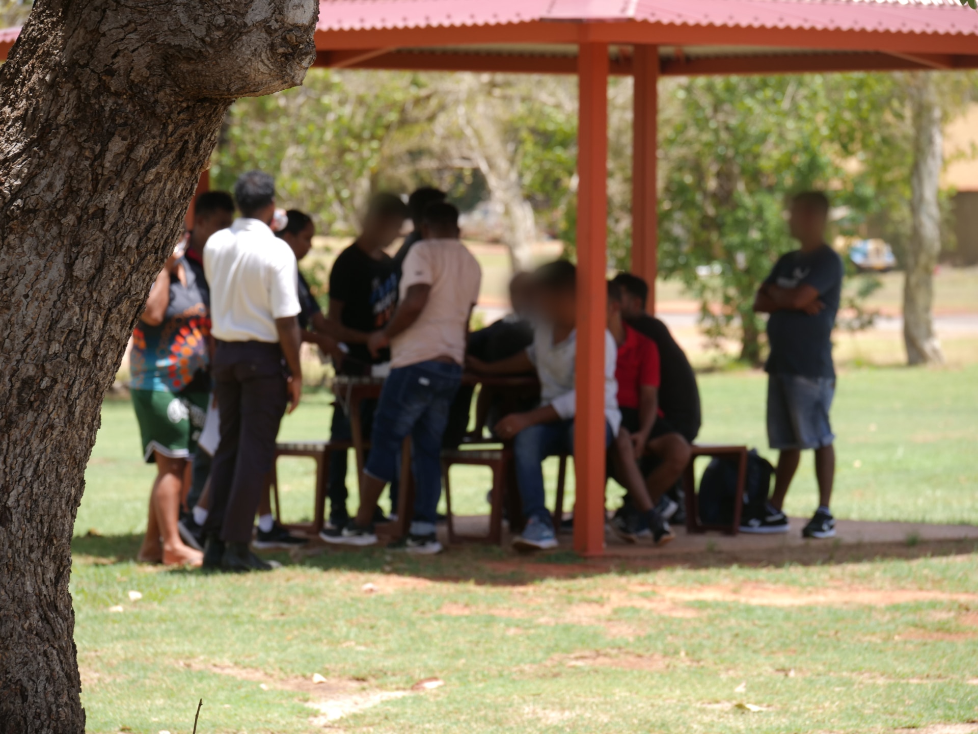 A group of people stand under a gazebo.