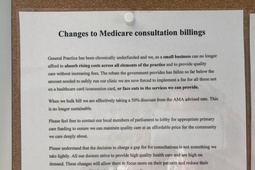 A sign is posted on a noticeboard telling patients the clinic is underfunded and charges will increase.