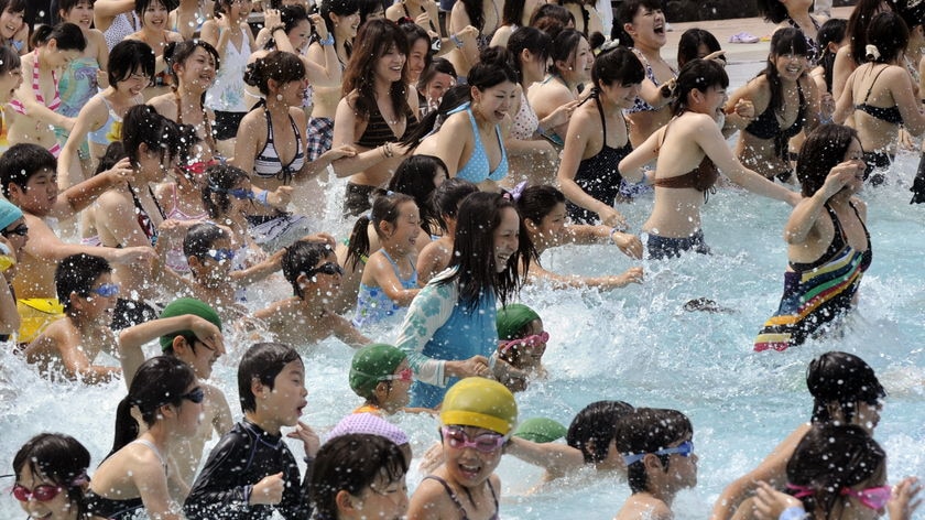 Japanese people splashing in a swimming pool. July 4, 2009.