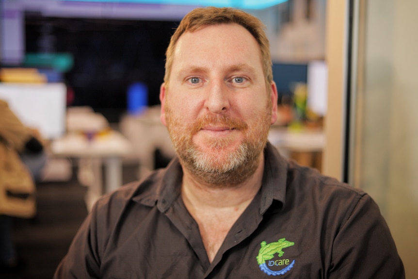 A man with a beard wearing black collared shirt.