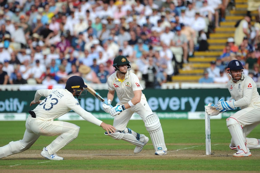 Steve Smith looks behind him while beginning to run. Jonny Bairstow looks in the same direction. Jos Buttler dives to his right.