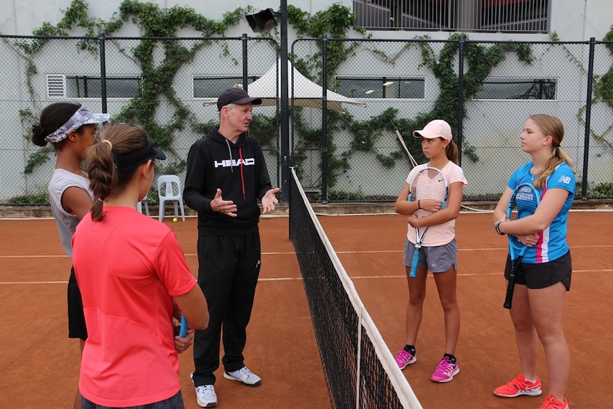 Jim Joyce at the Tennyson Tennis centre with players in the background.