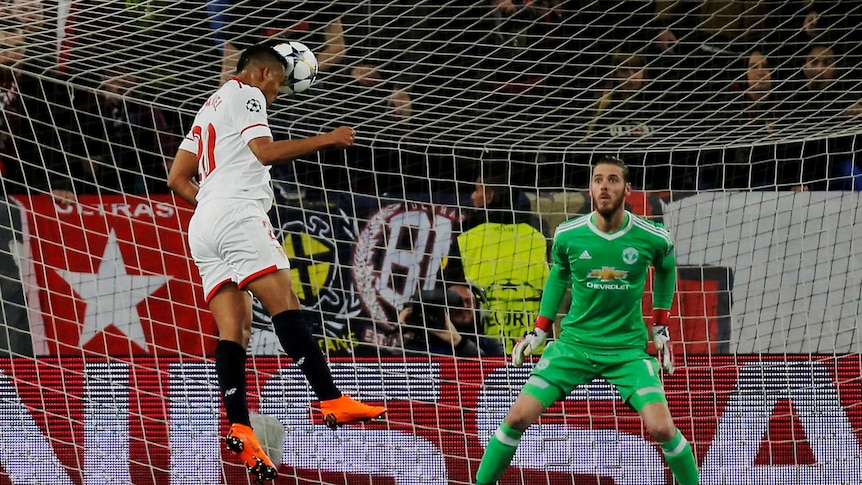 Sevilla's Luis Muriel heads the ball towards goal with Manchester United David De Gea watching.