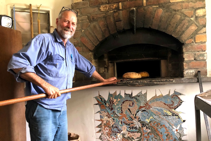 A man bakes bread in a woodfired oven