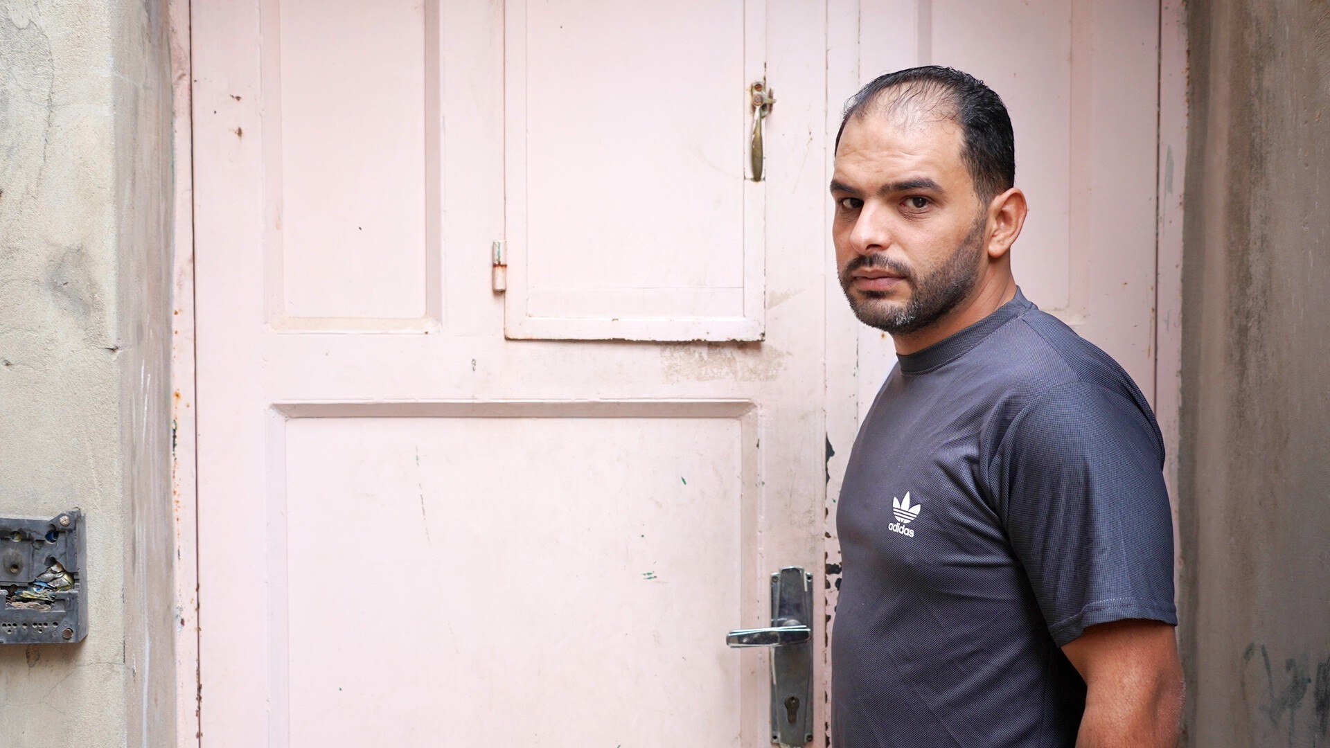 A man near a door looking at the camera