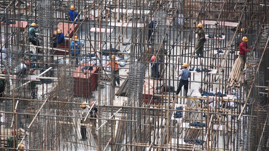 A Chinese construction site with workers pouring concrete