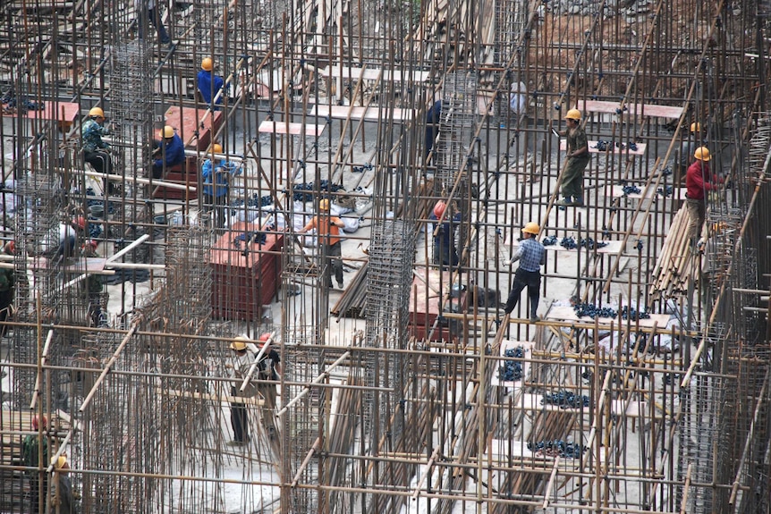 A Chinese construction site with workers pouring concrete