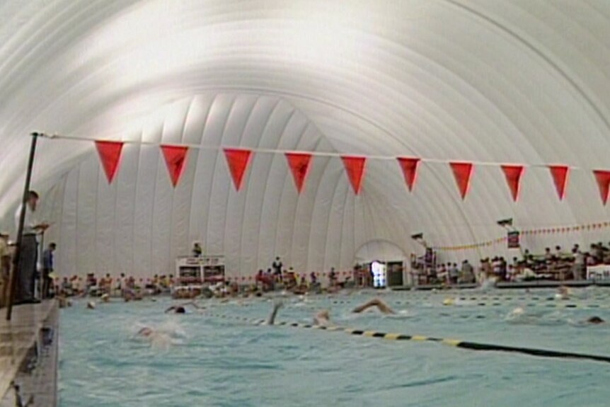 A swimming race taking place at the Clarence Pool in 1983, when the pool was covered by an inflatable white dome