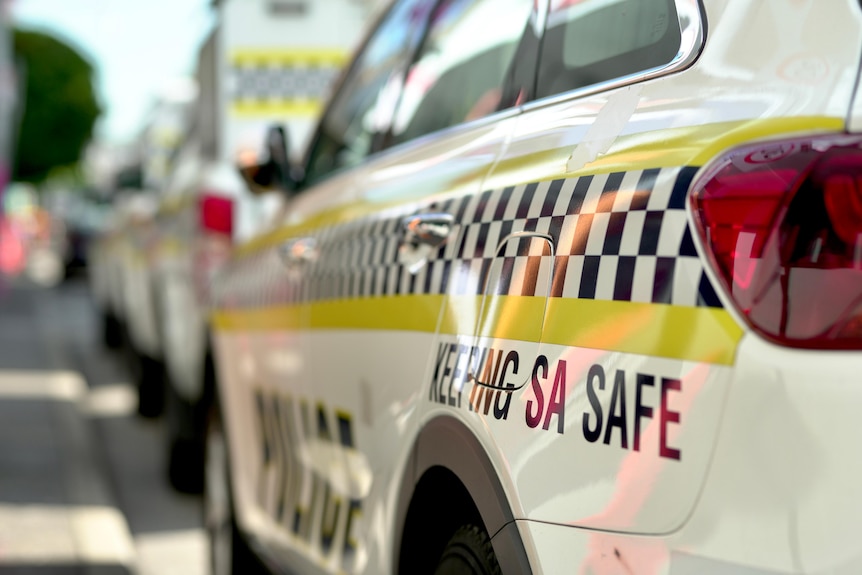 The side of a South Australian police car parked in a street.