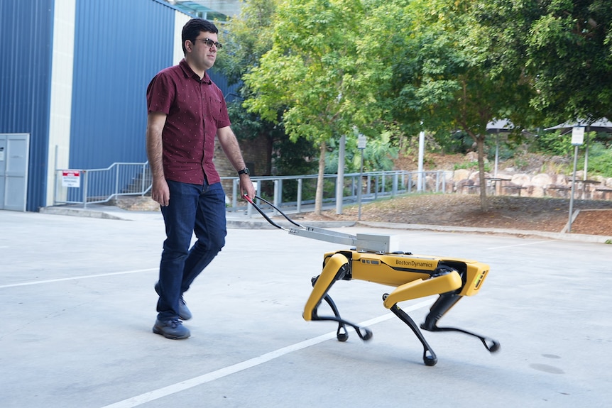 A man being led by a robot like a guide dog would