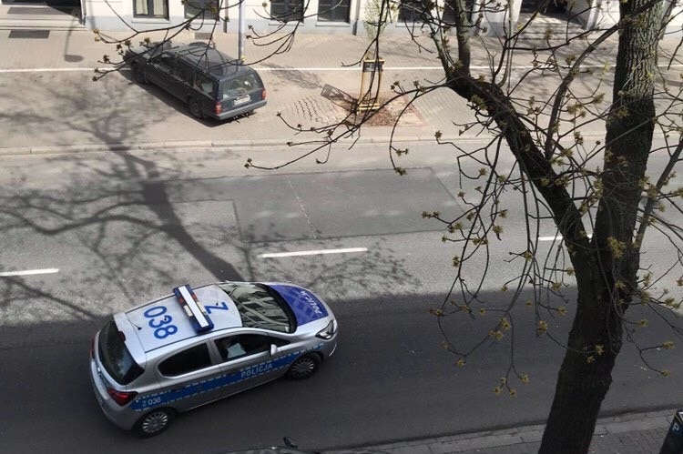The view of a police car on the street from an apartment window.