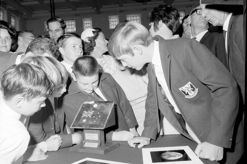 School students gathered around the presentation stand with moon fragments and flag from Apollo II, 1970.