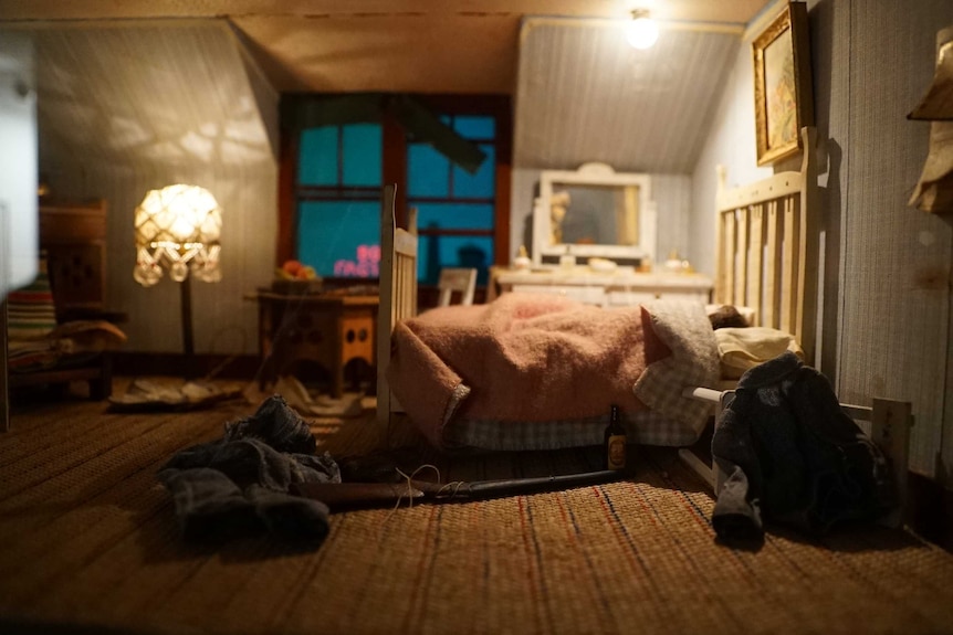 Vintage crime scene model - bedroom with clothes and gun on the floor.