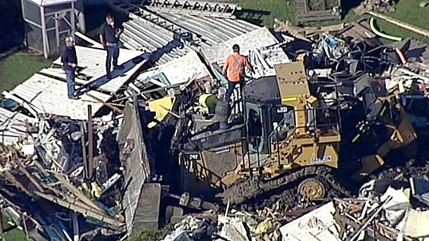 Stolen bulldozer sits amongst rubble of house