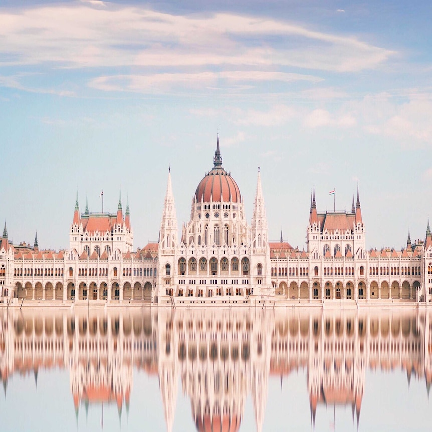 Reflection Of Hungarian Parliament Building In River Against Sky