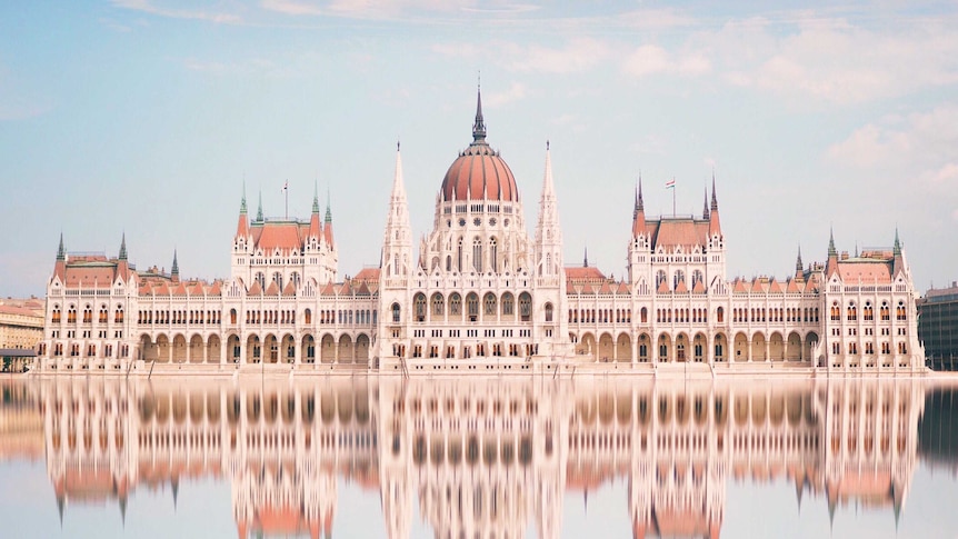 Reflection Of Hungarian Parliament Building In River Against Sky