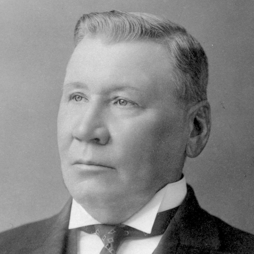 A black and white photo of a man wearing a suit