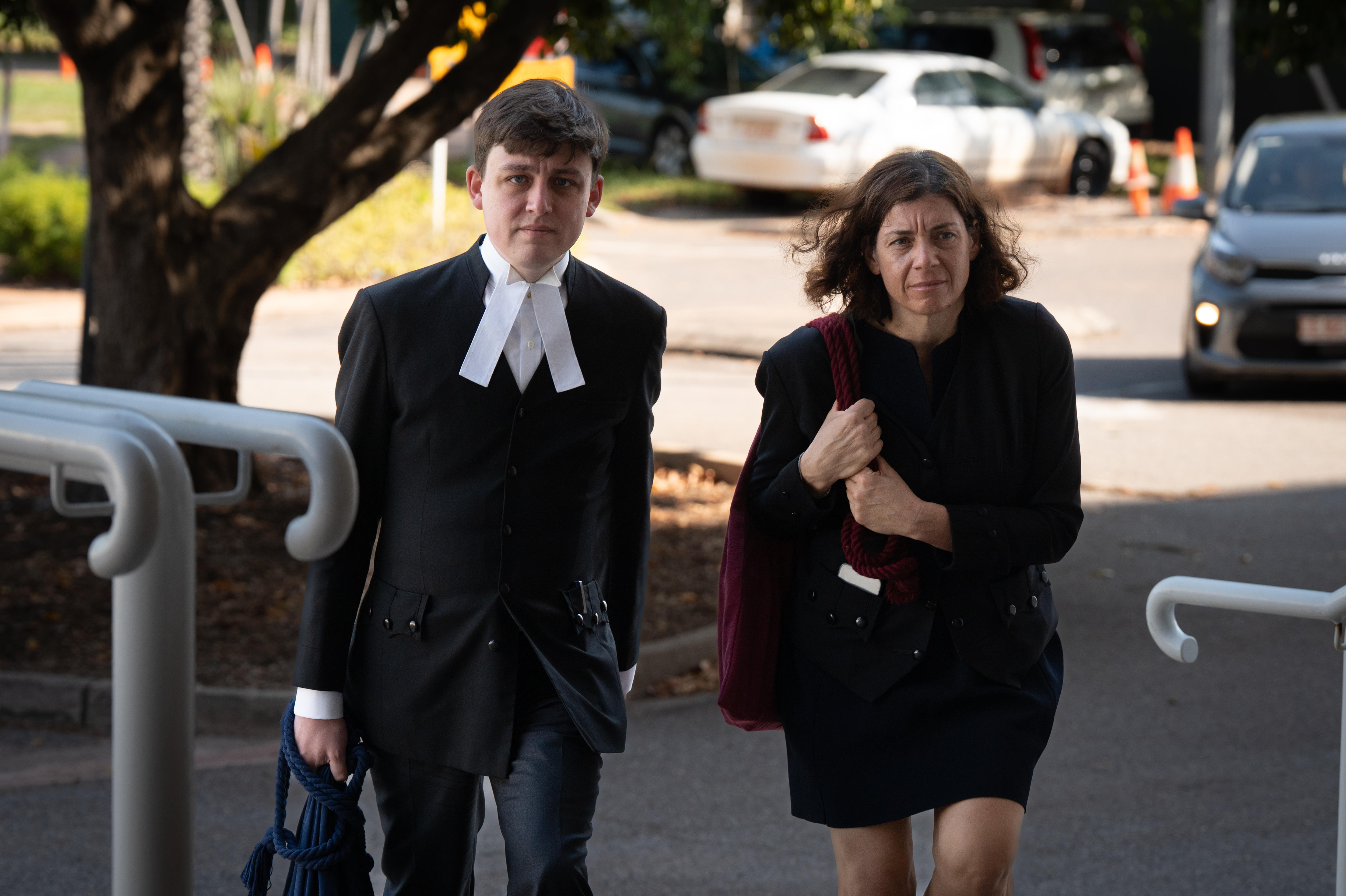 Uma mulher carregando uma sacola sobe as escadas do tribunal.