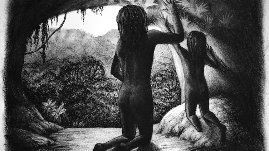 A black and white illustration of an adult and a child with one foot making hand paintings on a cave wall