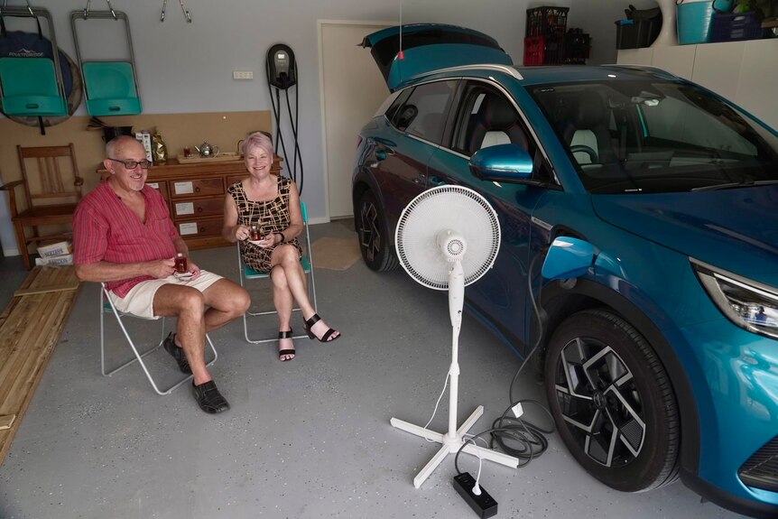 Andrew Panshin and his wife Jacinta sit in front of a fan powered by their EV